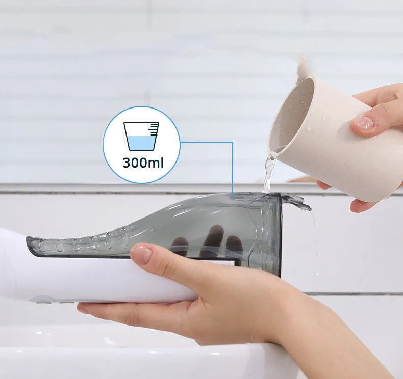 Portable white oral irrigator water flosser with large water tank and four coloured nozzles on a bathroom counter.