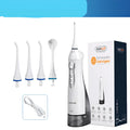 Portable white oral irrigator water flosser with large water tank and four coloured nozzles on a bathroom counter.