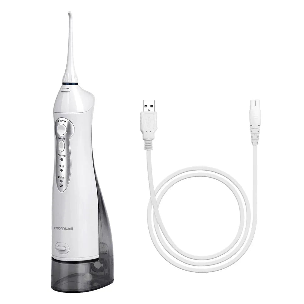Portable white oral irrigator water flosser with large water tank and four coloured nozzles on a bathroom counter.