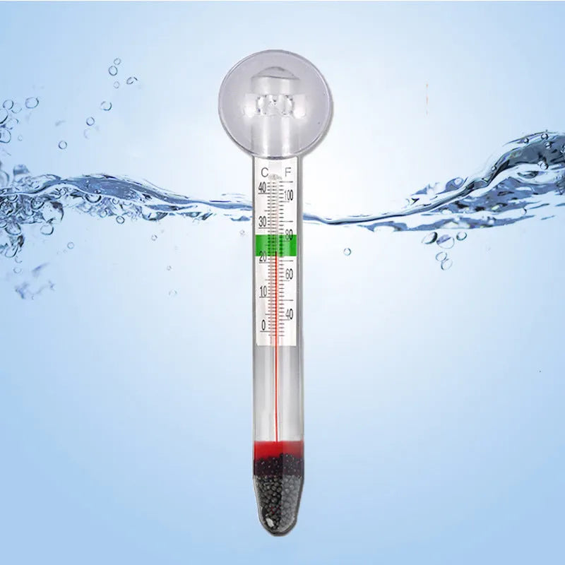 White glass aquarium fat thermometer with suction cup floating on water surface showing temperature scale