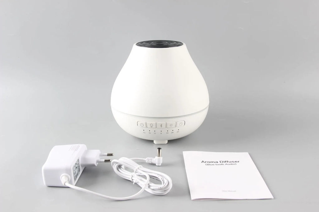 White round Soho & Co Bluetooth aroma diffuser emitting mist, with multi-colour LED glow and UK plug.