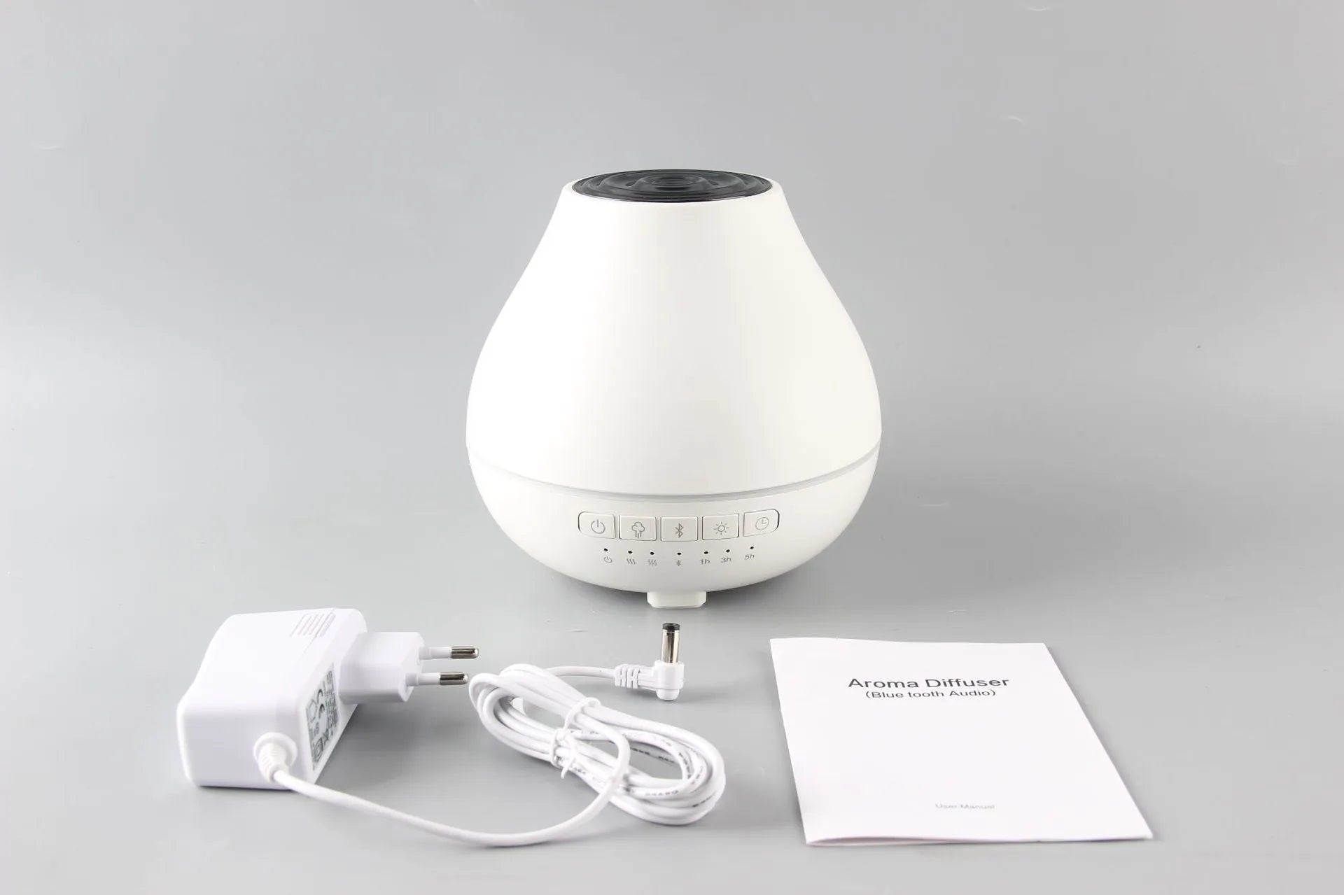 White round Soho & Co Bluetooth aroma diffuser emitting mist, with multi-colour LED glow and UK plug.