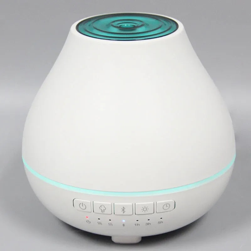 White round Soho & Co Bluetooth aroma diffuser emitting mist, with multi-colour LED glow and UK plug.