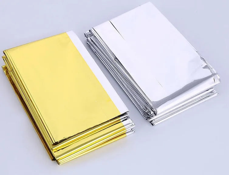 Gold silver emergency blanket made from PET film with reflective coating, 130x210cm size, for outdoor survival and rescue.