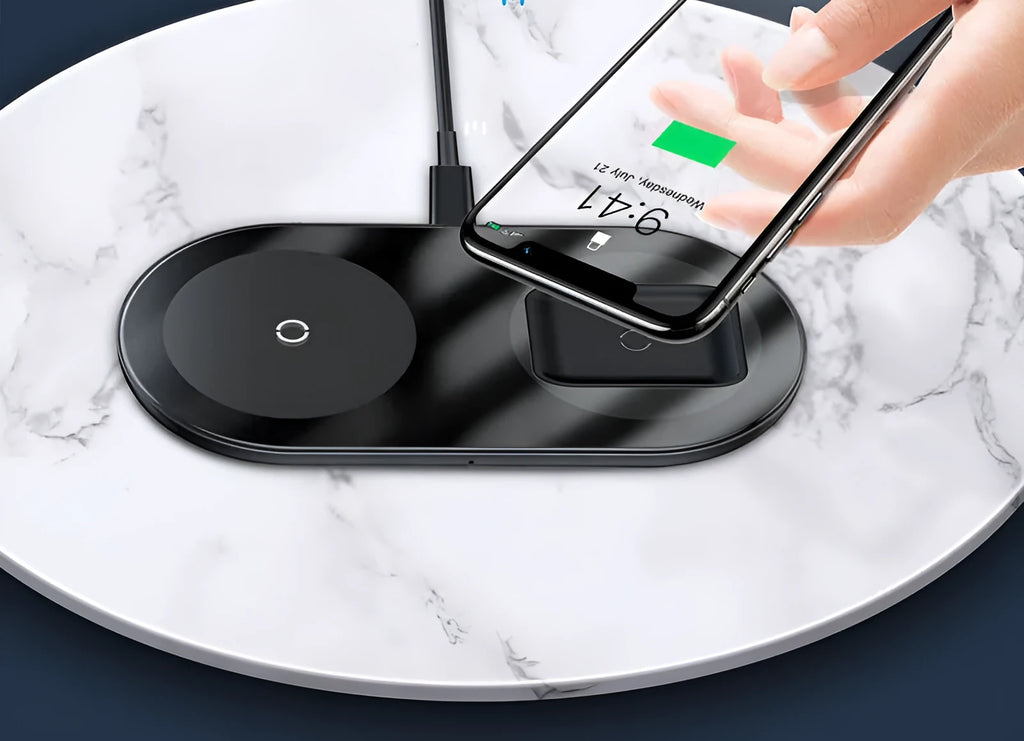 Baseus Minimalist Two-in-One Wireless Charging Pad in transparent finish on a wooden desk, charging a smartphone and AirPods case.
