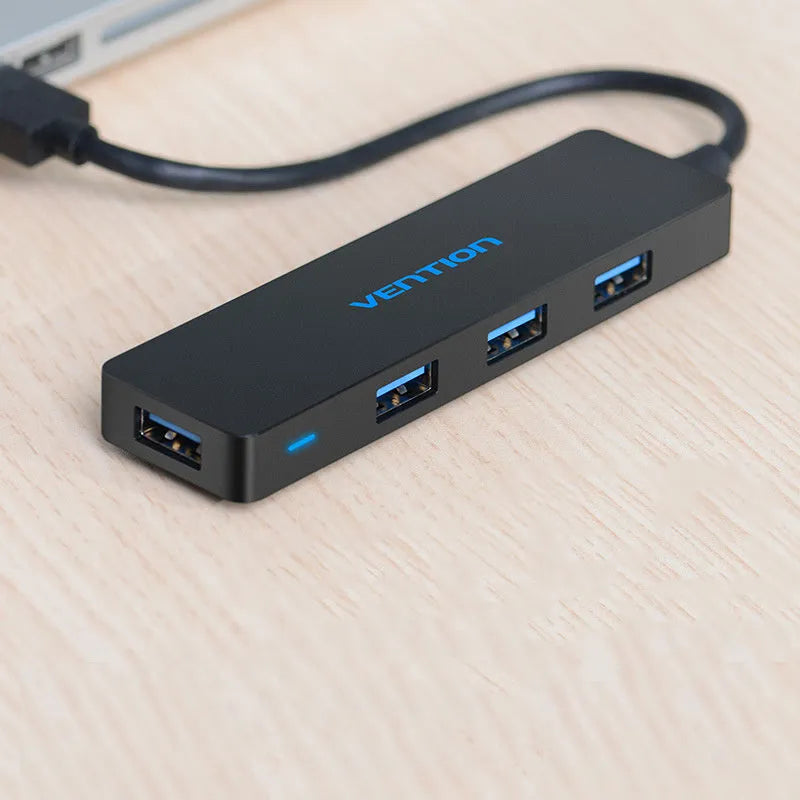 Black Wei Xun 4-port USB 3.0 hub with a short cable connected to a laptop
