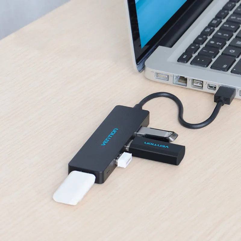 Black Wei Xun 4-port USB 3.0 hub with a short cable connected to a laptop