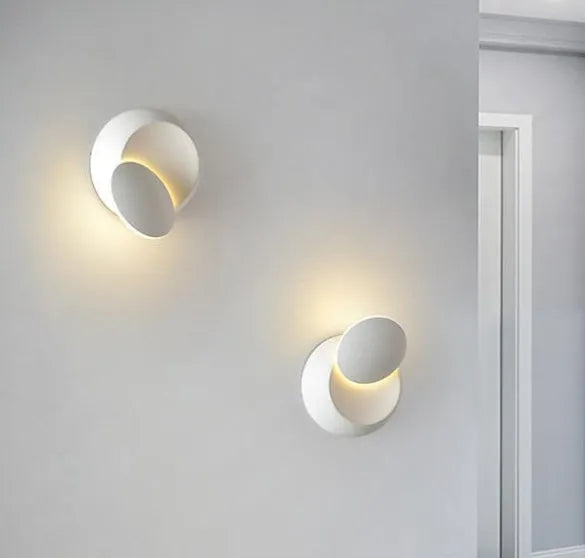 Rotating lunar eclipse LED wall lamp in black aluminium shade mounted on wall with pull-wire switch