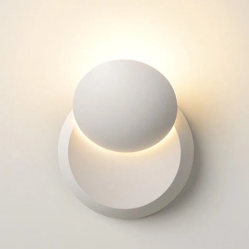 Rotating lunar eclipse LED wall lamp in black aluminium shade mounted on wall with pull-wire switch