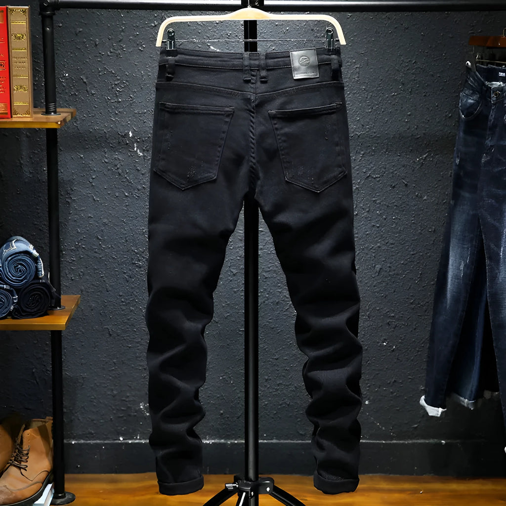 Men's black ripped stretch straight leg jeans with distressed detailing and zipper fly