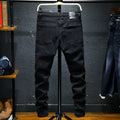 Men's black ripped stretch straight leg jeans with distressed detailing and zipper fly