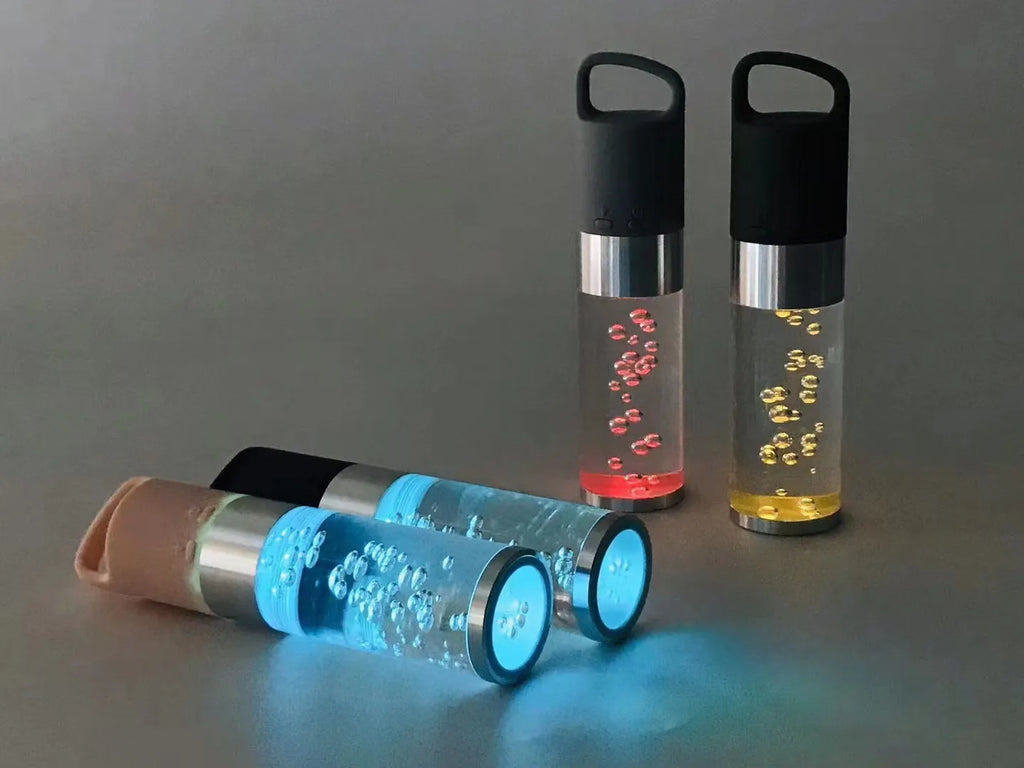 Pink portable Bluetooth speaker with a crystal light and carry handle on a white background.