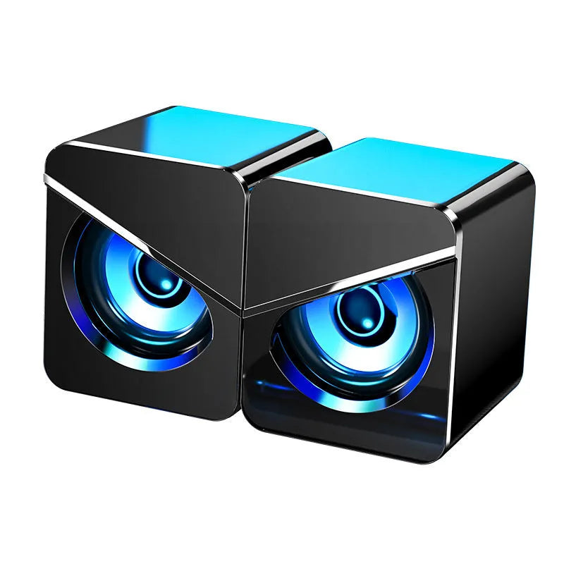 Black and white desktop computer speakers with 3.5mm audio jack connection on office desk