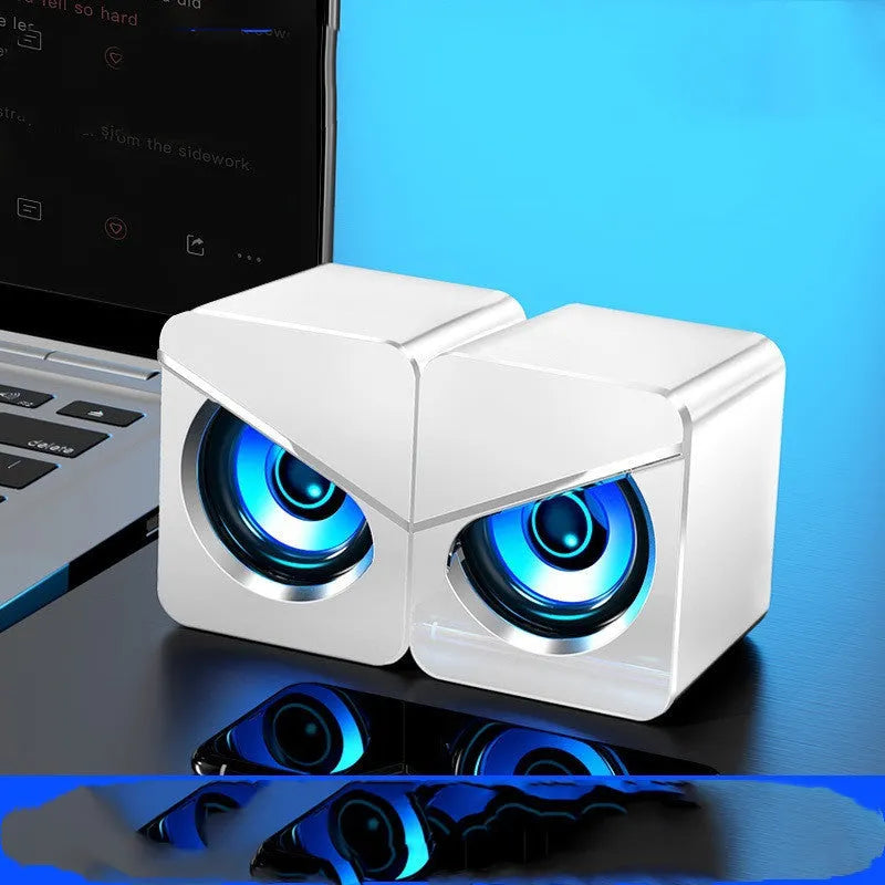 Black and white desktop computer speakers with 3.5mm audio jack connection on office desk