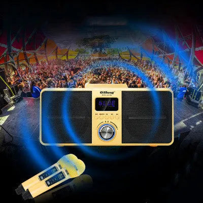 Black and gold Bluetooth karaoke speaker with two wireless microphones on a table.