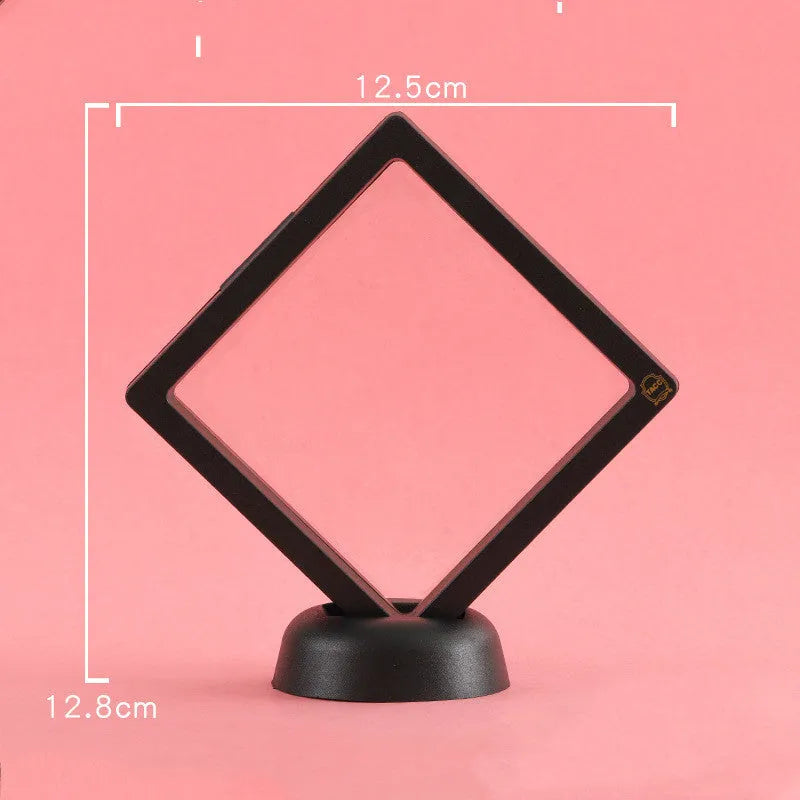 3D floating display case holding a coin suspended between transparent membrane sheets, black frame