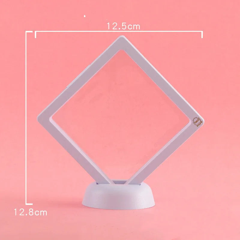 3D floating display case holding a coin suspended between transparent membrane sheets, black frame