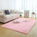 Machine woven plain rectangle fluffy rug in beige long-hair finish on a wooden floor