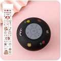 Small colourful waterproof Bluetooth speaker with a silicone suction cup base on a bathroom tile.