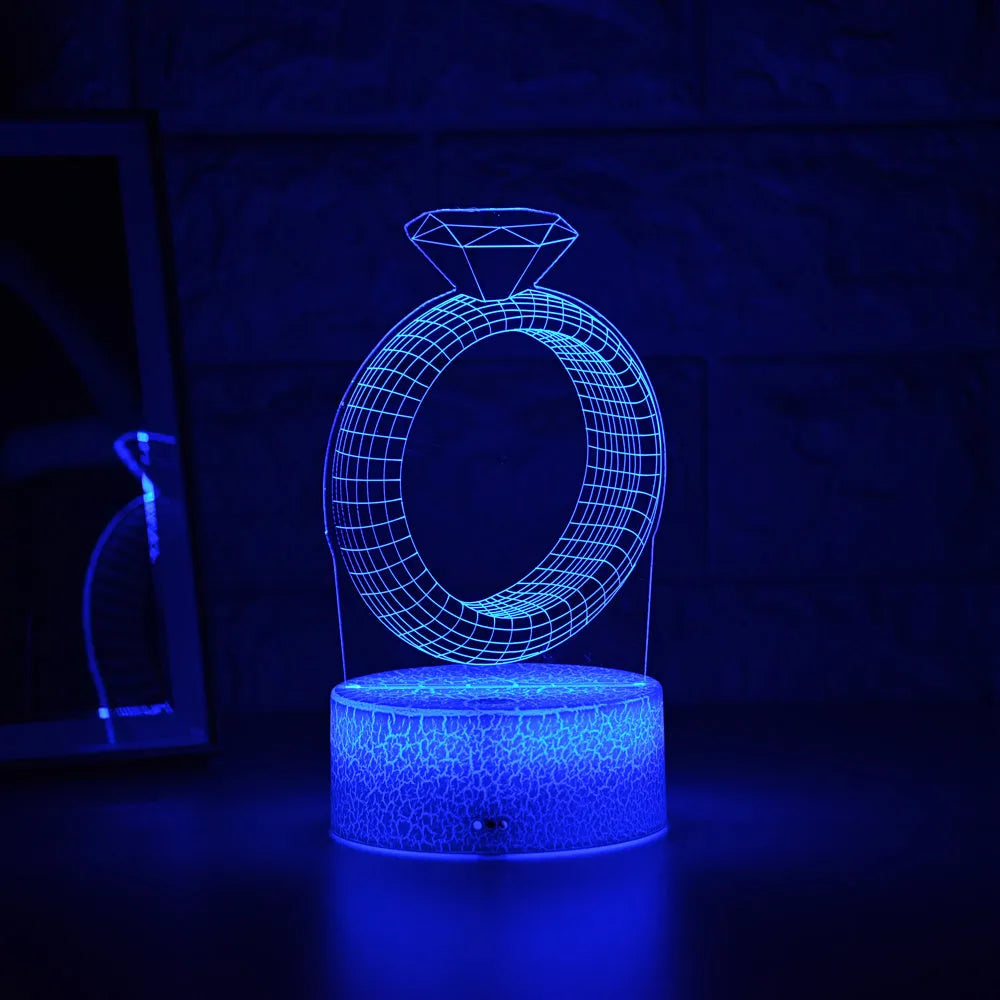 3D LED night light glowing with colour-changing light on a diamond ring laser engraving inside a black base.
