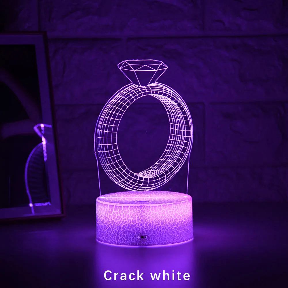 3D LED night light glowing with colour-changing light on a diamond ring laser engraving inside a black base.