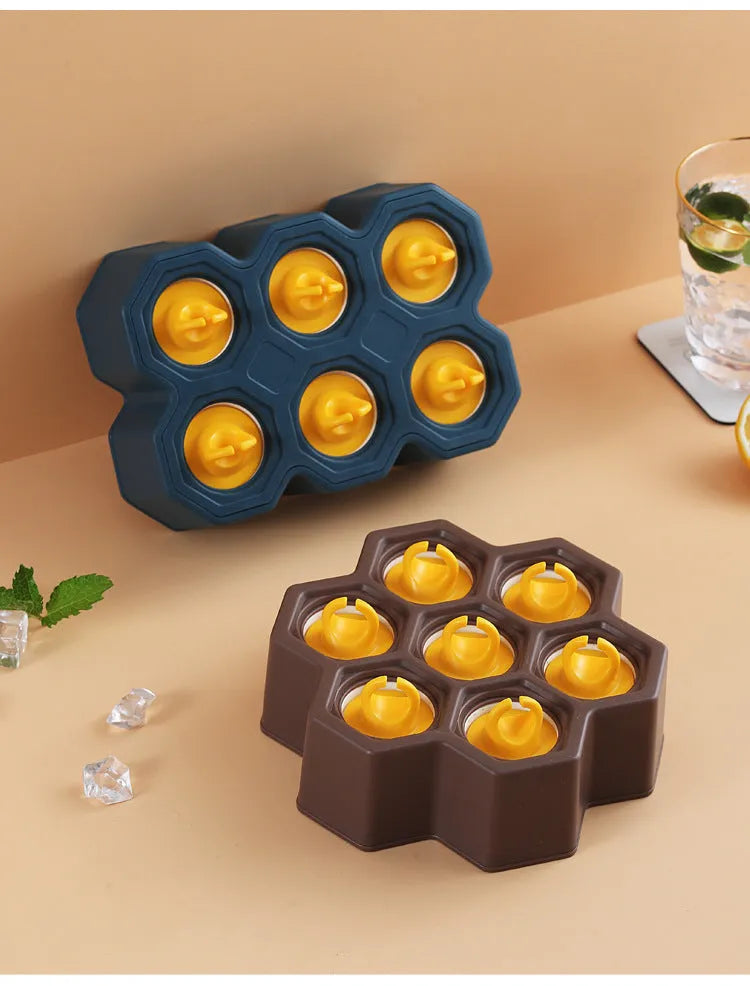 Brown plastic ice cube mould with cartoon anti-drip rim and honeycomb-shaped cavities