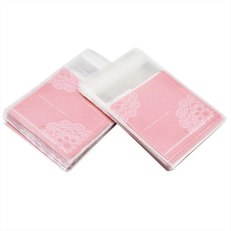 Clear self-adhesive plastic packaging bags with pink UV print, showing 7cm by 7cm size and gusset.