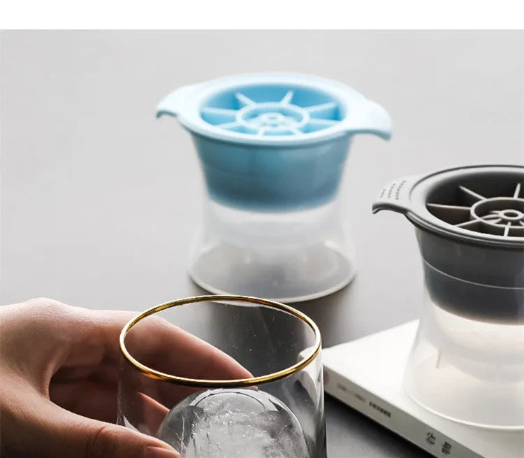Flexible silicone ice tray showing large ice hockey, pentagon, and spherical mould designs in light blue.
