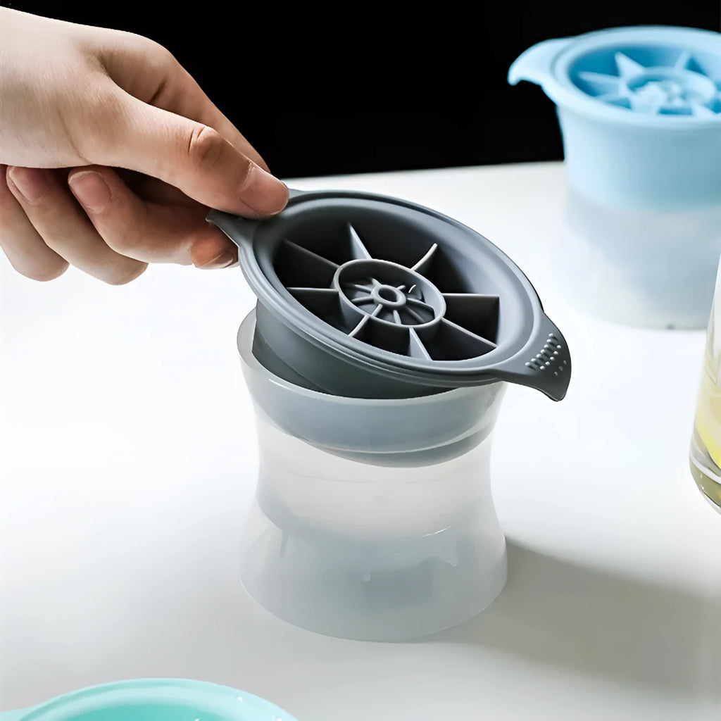 Flexible silicone ice tray showing large ice hockey, pentagon, and spherical mould designs in light blue.