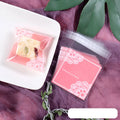 Clear self-adhesive plastic packaging bags with pink UV print, showing 7cm by 7cm size and gusset.