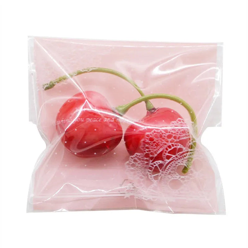 Clear self-adhesive plastic packaging bags with pink UV print, showing 7cm by 7cm size and gusset.