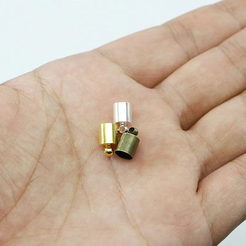 Assortment of small, bell-shaped copper caps in gold, silver, bronze, and black finishes for jewellery making.