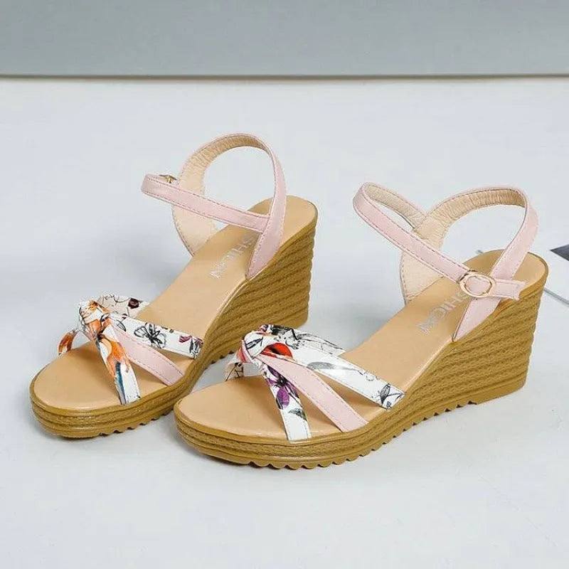 Women's pink wedge sandals with a thick heel, fish mouth open toe, and an ankle buckle on a white background.