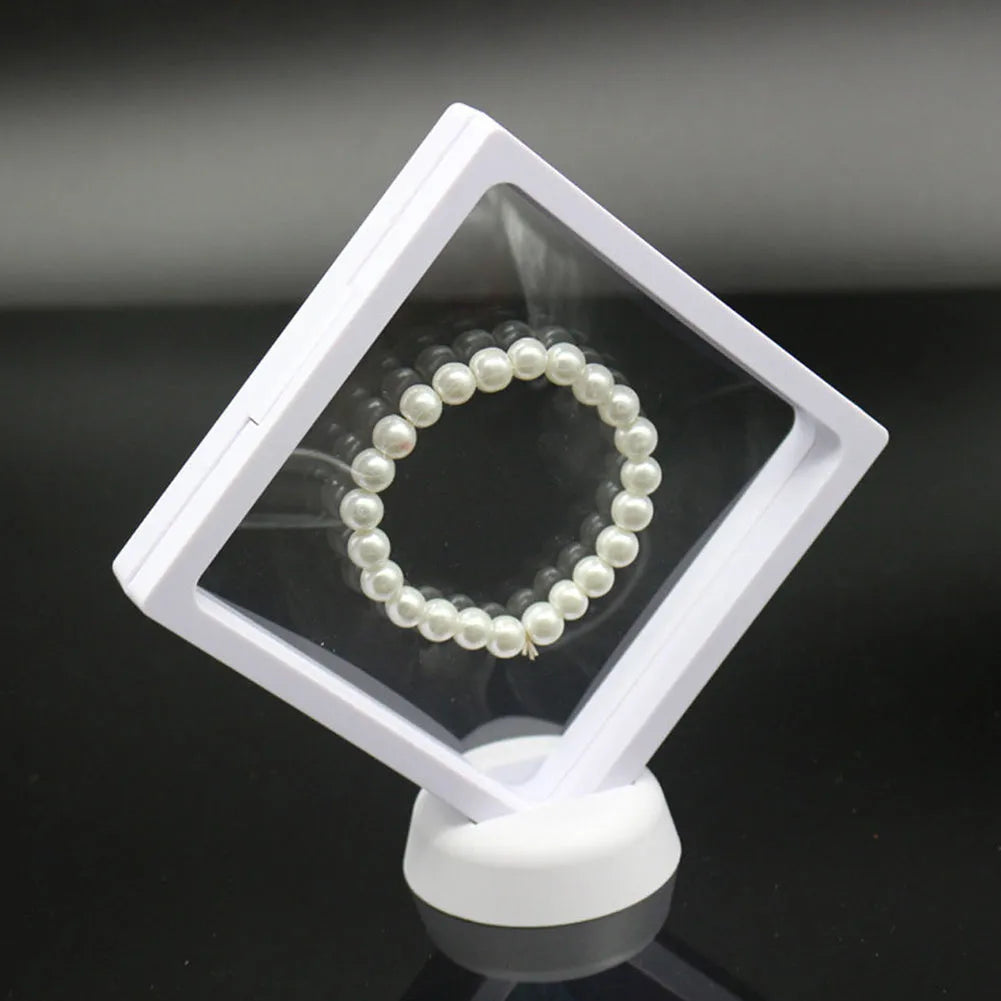 3D floating display case holding a coin suspended between transparent membrane sheets, black frame