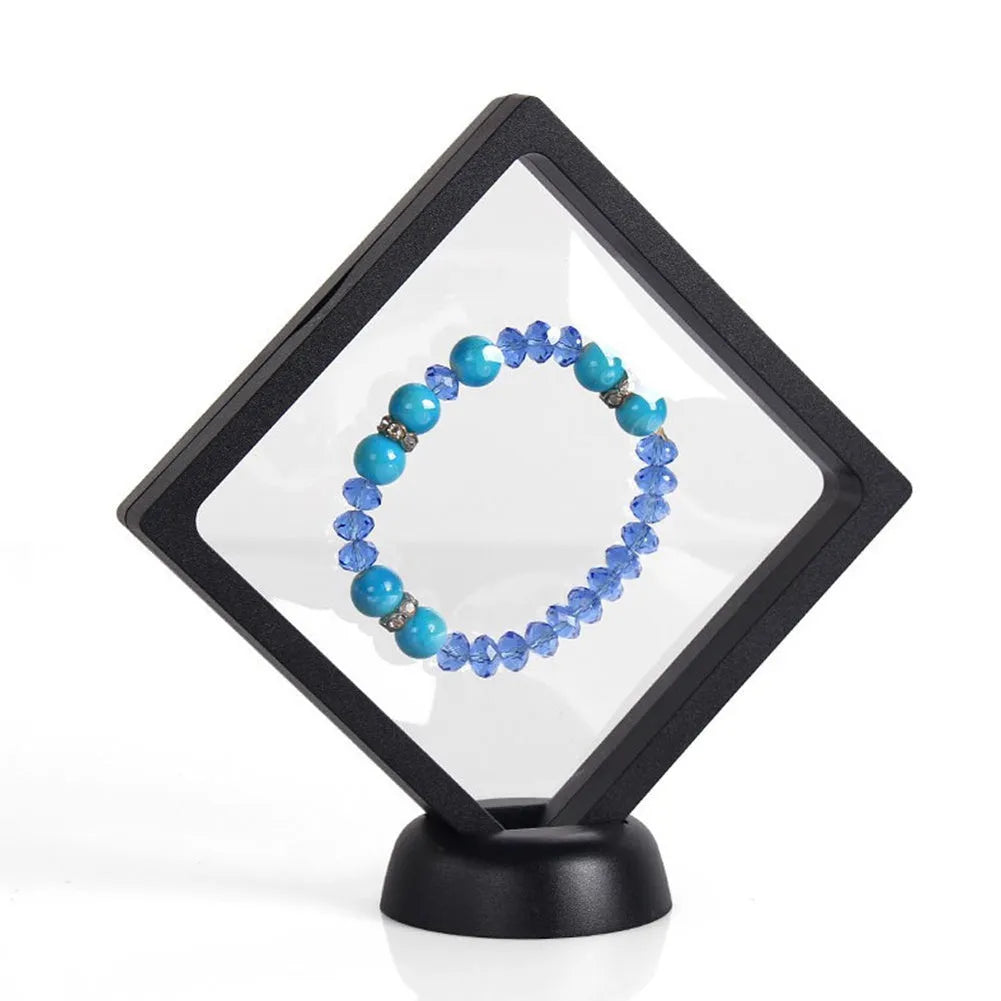 3D floating display case holding a coin suspended between transparent membrane sheets, black frame