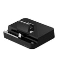 Black mobile phone to HD video converter dock on a wooden table, showing compact size and single black base design.