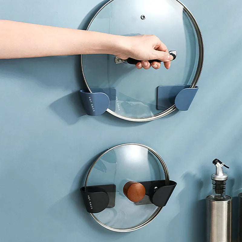 Simple wall-mounted non-punching pot cover rack in black, ABS plastic, 16.5x5x4.5cm, holding pot lids on a kitchen wall