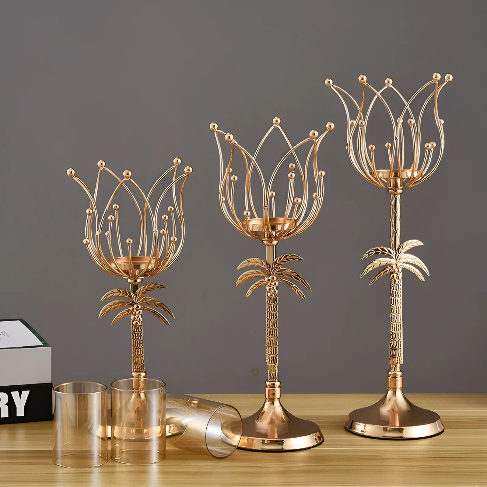 Gold iron candle holder on a dining table with a lit candle, three height options available