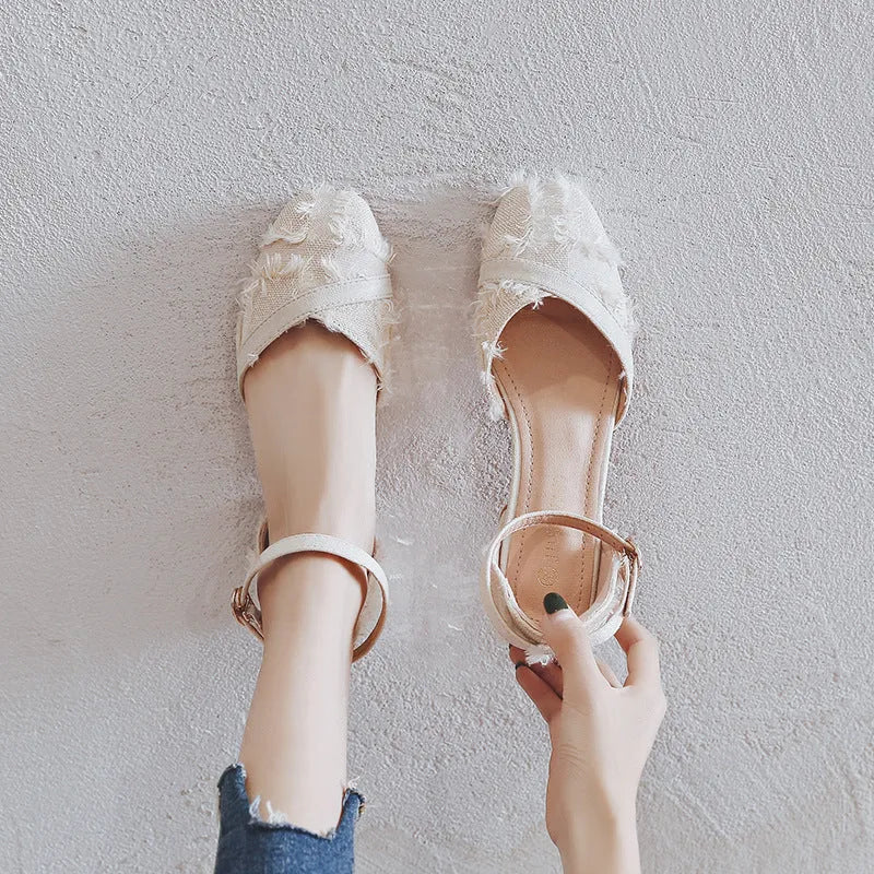 Women's apricot suede D'Orsay flats with an ankle strap and a 3cm low block heel on a wooden floor.