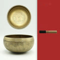 Handmade copper singing bowl with auspicious knot design on a soft surface with leather stick