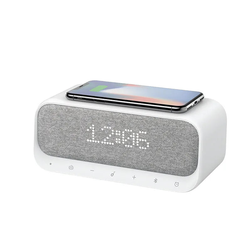 White Anker Soundcore Bluetooth speaker with wireless charging pad and digital clock display