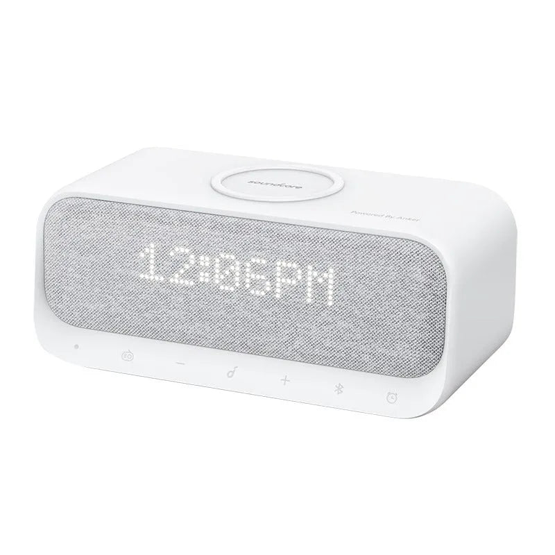 White Anker Soundcore Bluetooth speaker with wireless charging pad and digital clock display