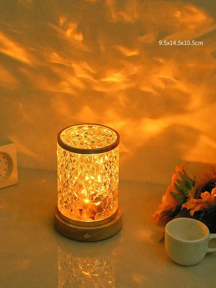 Small rotating water ripple night light with an acrylic shade on a solid wood base.
