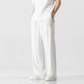 Man wearing beige cropped straight-leg bamboo fibre trousers with a drawstring waist on a summer day.