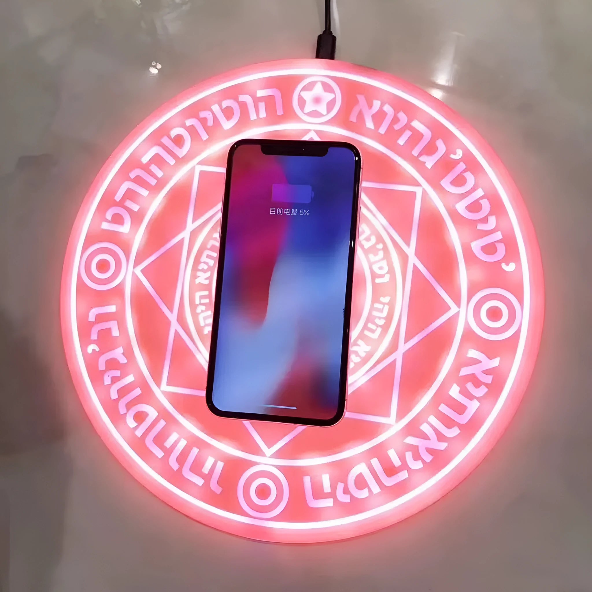 Square black 10W fast wireless charging pad with glowing magic array pattern for Qi phones.