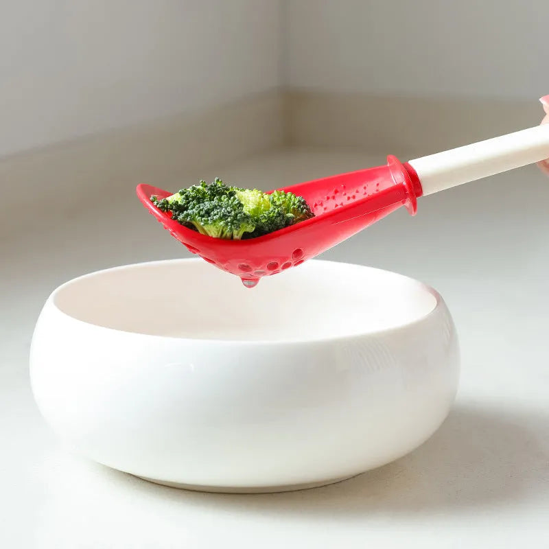 Red and black plastic multifunctional slotted cooking spoon with serrated edges for mashing and grinding.