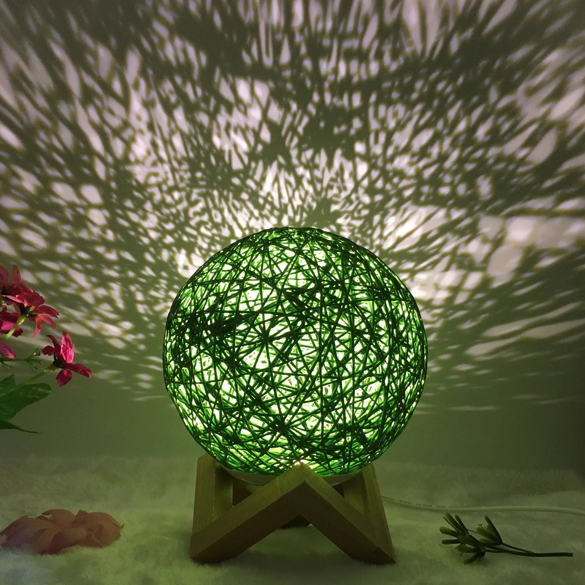 Rattan ball table lamp with woven shade and warm LED lighting on wooden surface
