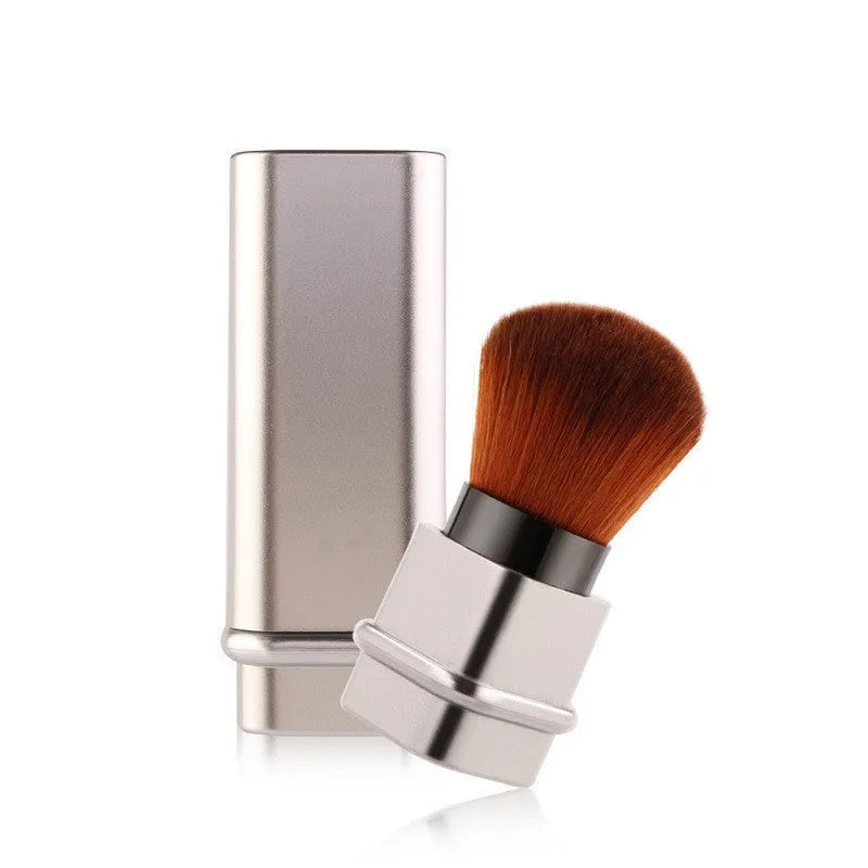 Portable single makeup brush with man-made fibre bristles and square gold plastic handle on white background