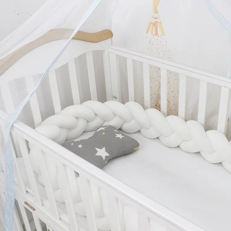 Long, flexible baby crib bumper pillow in spandex velvet, shown fitted around a white cot for safety protection.