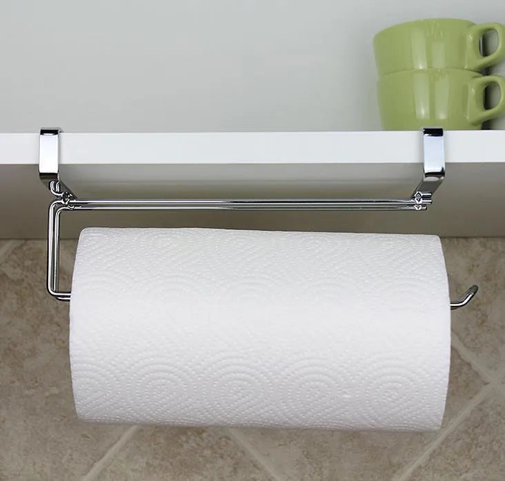 Silver stainless steel rack hanging on the back of a kitchen cabinet door holding a paper towel roll.